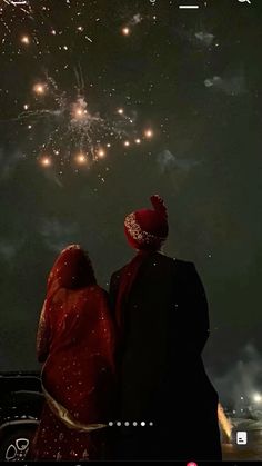 two people looking at fireworks in the sky