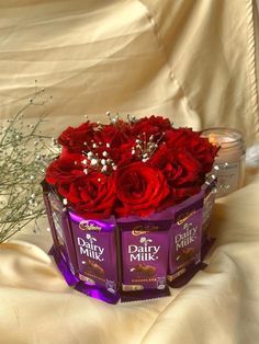 two boxes of dairy milk and roses on a white cloth with some baby's breath in the background