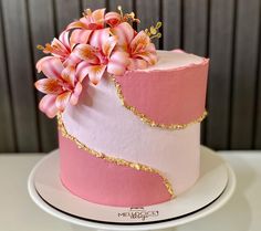 a pink and white cake with flowers on top