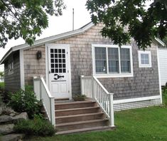 a small house with steps leading to the front door