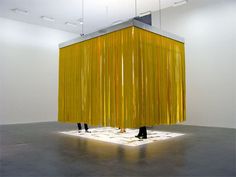 a large yellow object is in the middle of a room with white walls and flooring