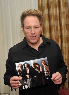 a man holding up a photo of himself