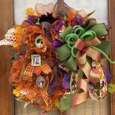 a wreath made out of fabric and ribbons on the front door with a photo frame attached to it