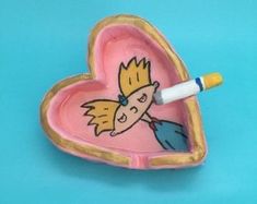 a pink heart shaped box with a drawing of a girl on it and a marker in the middle