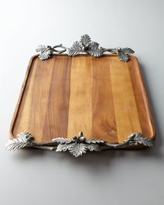 a wooden tray with metal leaves on it