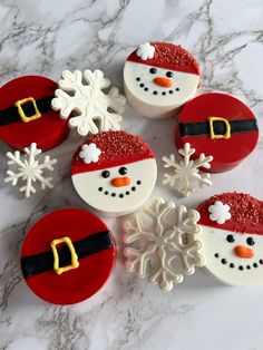 decorated cupcakes with santa hats and snowflakes on a marble countertop