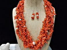 "This Luxe necklace and earrings set is made of Orange Coral Sticks and White Freshwater Pearls.  This is a really, really unique necklace.   It was created with a five strands of orange coral sticks, with several white fresh water pearls interspersed among the coral sticks. The result was this striking necklace!  There are also matching earrings to complete the set.  You or someone you care about will LOVE this one of a kind necklace and earrings set. This is an orange coral stick gemstone stat Cheap Orange Statement Necklaces, Cheap Statement Orange Necklace, Cheap Orange Statement Necklace, Cheap Bold Orange Jewelry, Luxury Unique Orange Beaded Necklaces, Luxury Orange Beaded Necklaces As Statement Piece, Luxury Handmade Orange Necklace, Coral Earring, Jean Art