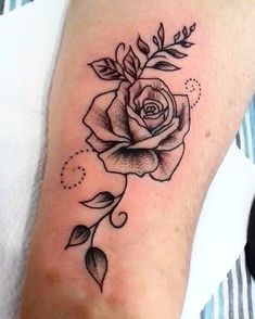 a black and white rose tattoo on the arm