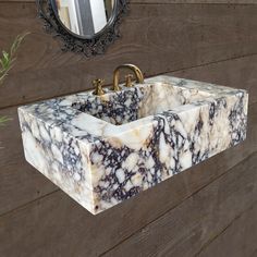 a marble sink in front of a wooden wall