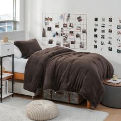 a bed sitting in a bedroom next to a wooden table with a white rug on top of it