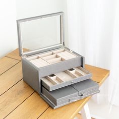 an open jewelry box sitting on top of a wooden table