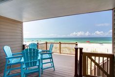 a balcony with blue chairs overlooking the beach