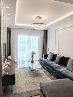 a living room filled with furniture and a flat screen tv mounted to the side of a wall