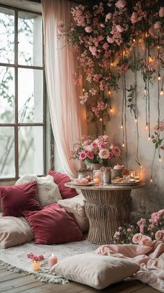 a living room filled with lots of pink flowers and candles next to a large window