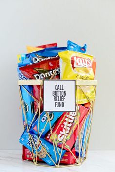 a basket filled with lots of candy sitting on top of a white counter next to a sign that says call button relief fund