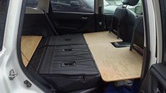 the back seat of a vehicle with a wooden table in the passenger side door area