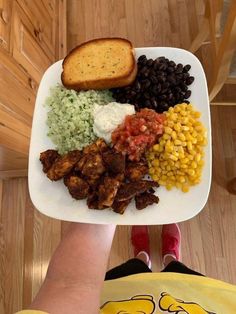 a person holding a plate with different types of food on it