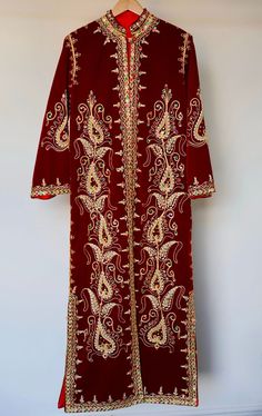 Your 1970s caftan dress represents a timeless piece of elegance, skillfully blending oriental tradition with vintage refinement. Its elaborate manual embroideries, crafted with golden thread, semi-precious pearls, and delicate sequins, showcase the exceptional craftsmanship of its time. Every detail reflects the artisanal mastery of that era, highlighting the passion and devotion of the creators behind this sartorial masterpiece. The dress's pristine condition, preserved like new, serves as evidence of meticulous care throughout the decades. More than just a garment, it becomes a chronicle of timeless elegance and the tradition of beauty. It carries not only the history of fashion but also the imprint of an era where textile art and intricate details reached their zenith. Dimensions: 40 in Traditional Floor-length Kaftan With Patterns, Traditional Floor-length Kaftan With Traditional Patterns, Traditional Maxi Dress With Traditional Patterns, Ceremonial Dresses With Intricate Embroidery For Festivals, Fitted Floor-length Kaftan With Traditional Patterns, Embroidered Long Sleeve Dress For Transitional Season, Long Sleeve Embroidered Transitional Dress, Traditional Tunic Maxi Dress For Festive Occasion, Traditional Patterned Floor-length Kaftan For Festivals