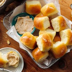 several rolls and dips on a table with bread in the basket next to them