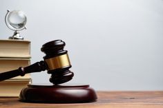 a judge's gavel sitting on top of a wooden table next to books