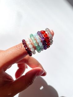 Please read before ordering: Listing is for one stretchy crystal ring of your choice. All rings are handmade by me ♡ Sizes available: 4-10 US(for size not listed, feel free to contact me directly) - for half sizes, size up to the next whole size. Each ring is made out of stretchy elastic with a gold filled bead. Jewelry care: ♡ Avoid contact with water, perfume, oils - consistent contact with these elements may cause breakage over time. ♡ Slide ring onto desired finger instead of stretching. ♡ R Stretchy Rings Diy, Rings With Seed Beads, Elastic Rings Diy, Adjustable Round Band Crystal Gemstone Ring, Adjustable Crystal Ring With Round Gemstone Band, Adjustable Round Band Crystal Ring With Gemstone, Stackable Round Crystal Ring, Beaded Promise Rings, Cheap Adjustable Rings With Colorful Beads