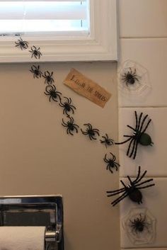 bathroom decorated for halloween with spider webs on the wall and toilet paper dispenser