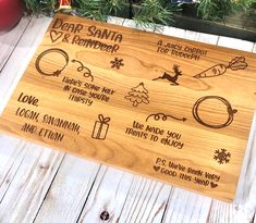 a wooden cutting board with different types of christmas related items on it next to a christmas ornament