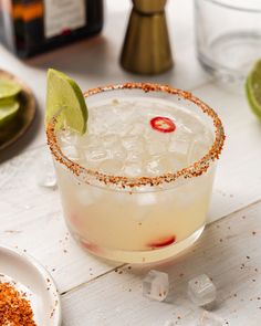 an alcoholic cocktail is garnished with salt and lime