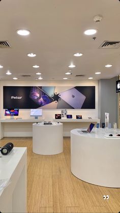 the inside of a store with several different items on tables and lights above them, including cell phones