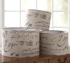 three rolls of toilet paper with writing on them sitting in front of a white window