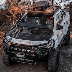 a black and white truck parked on top of a dirt road