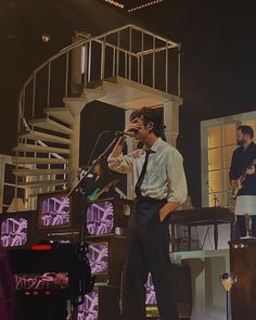 a man standing in front of a microphone on stage