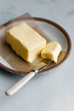 two pieces of butter on a plate with a knife