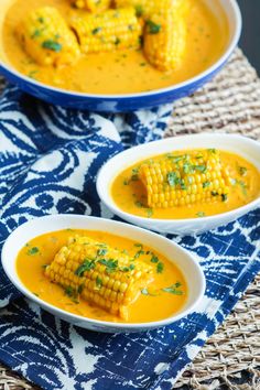 three bowls of soup with corn on the cob