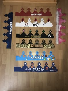 several pieces of puzzle on the floor with name tags attached to each piece and numbers in different colors