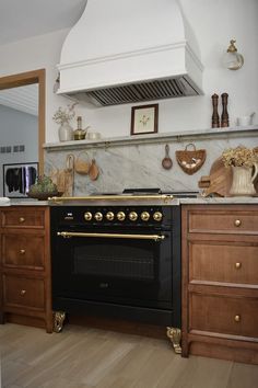 a stove top oven sitting inside of a kitchen next to wooden cabinets and counter tops