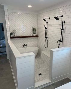 a bathroom with white tile and black fixtures in the bathtub, shower head, and toilet seat