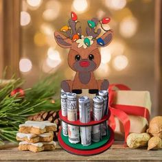 a reindeer with christmas lights on his head is sitting in front of some cookies and crackers