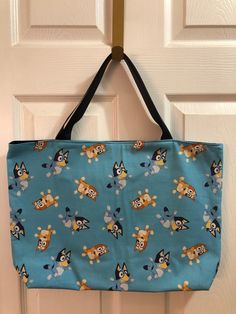 "This Bluey and Bingo tote bag is made of cotton and is machine washable. It is fully lined and interfaced and has 2-18\" navy straps. It measures 14\" down by 18\" across. It will make a great gift for any Bluey fan." Blue Softback Bags For Everyday, Blue Softback Shoulder Bag For Daily Use, Casual Blue Softback Bags, Blue Canvas School Bag, Blue Canvas Shoulder Bag For Shopping, Blue Canvas Bag With Adjustable Strap For School, Large Blue Bag For Everyday Use, Blue Beach Bag With Double Handle For Everyday, Blue Reversible Shoulder Bag For Daily Use