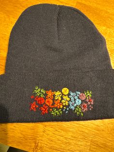 a gray beanie with colorful flowers on it