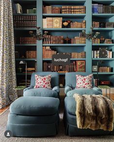 a living room filled with blue couches and bookshelves