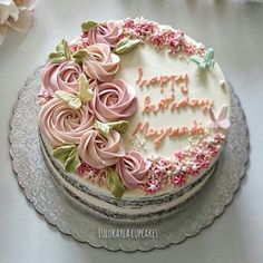 a birthday cake decorated with pink and green flowers