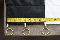 measuring tape and two pairs of scissors on top of a piece of wood with an american flag in the background