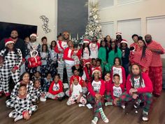 a group of people dressed in christmas pajamas posing for a photo