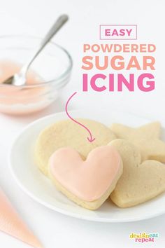 easy powdered sugar icing recipe on a plate with heart shaped cookies and spoon