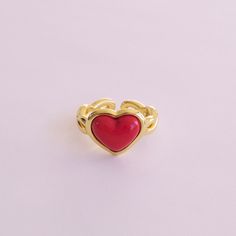 Made from delicate porcelain, this ring features a vibrant red heart-shaped centrepiece that captures the essence of love and romance. The rich, deep red hue adds a touch of warmth and passion, making it a perfect accessory for any occasion. The heart is encased in a 18K gold-plated setting and a braided band.   MATERIAL Handmade porcelain  18K Gold-plated brass    SIZE & FIT Ring size: EU 54/US 7 Ring diameter: 17. 2mm Product size: 14mm x22mmx25mm  COLOUR Red, gold  WEIGHT 6g   Handmade in Den Red Enamel Elegant Rings, Elegant Red Heart Ring For Gift, Elegant Red Enamel Ring, Valentine's Day Gold Heart Enamel Ring, Valentine's Day Red Heart Ring, Red Heart Cut Ring, Red Open Enamel Ring, Pink Enamel Ring For Valentine's Day Gift, Red Open Ring For Valentine's Day