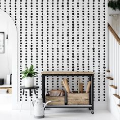 an entryway with black and white polka dot wallpaper on the walls, two wooden crates in front