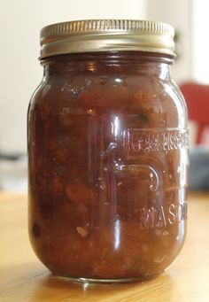 a glass jar filled with food sitting on top of a wooden table