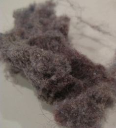 two pieces of gray wool sitting on top of a white countertop next to each other