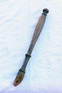 an old wooden baseball bat laying on top of a white sheet